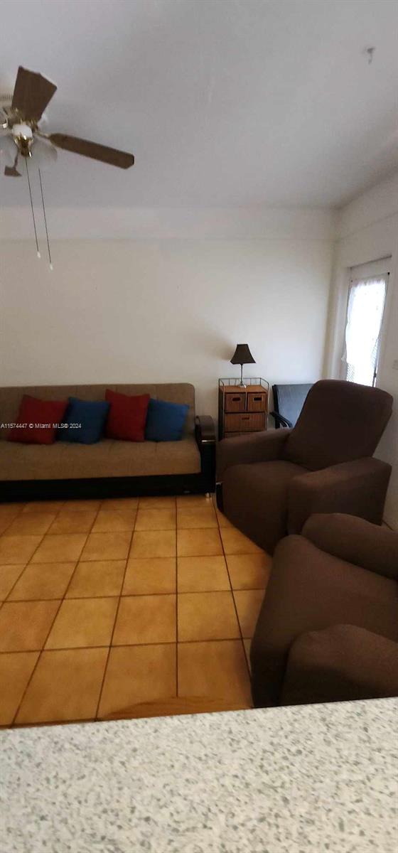 tiled living room with ceiling fan