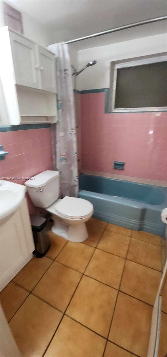 full bathroom with shower / bath combo, tasteful backsplash, tile floors, and tile walls