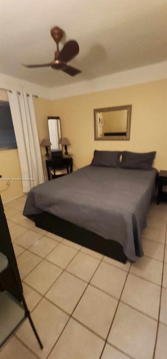 tiled bedroom featuring ceiling fan