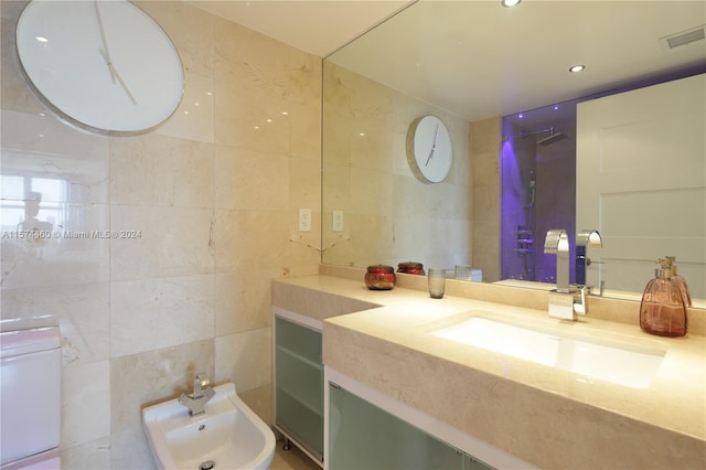 bathroom with vanity, tile walls, and a bidet