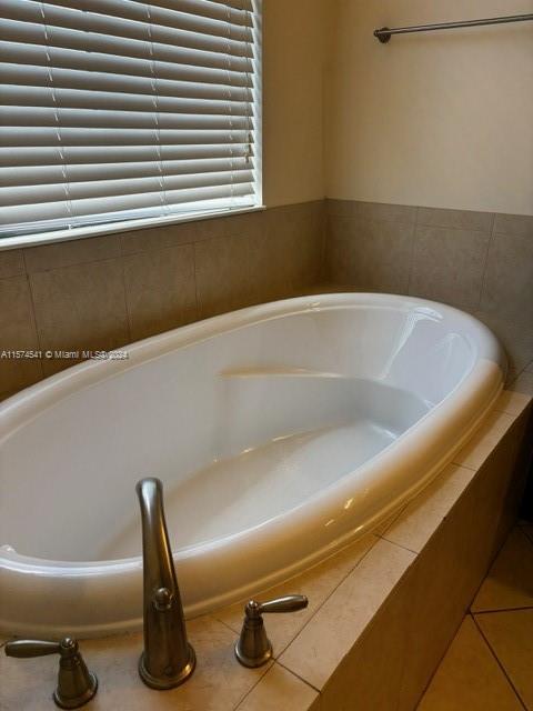 bathroom featuring tile floors and tiled tub