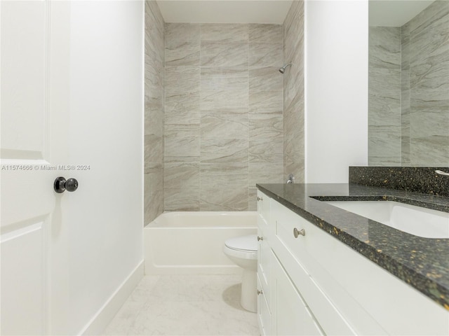 full bathroom featuring tiled shower / bath, vanity, and toilet