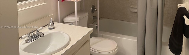 full bathroom with vanity, tiled shower / bath combo, and toilet