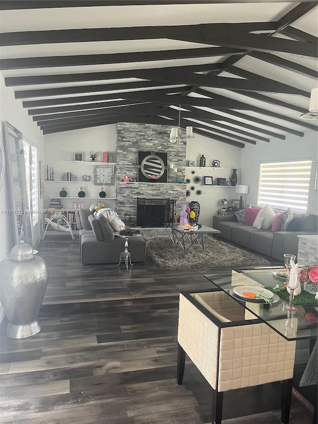 living room featuring lofted ceiling with beams, dark hardwood / wood-style flooring, and a stone fireplace