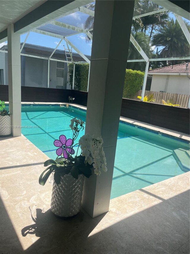 view of pool with a patio and glass enclosure