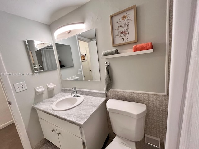 bathroom featuring tile flooring, vanity, and toilet