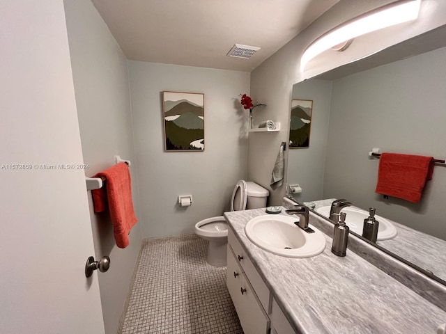 bathroom featuring toilet, tile flooring, and large vanity