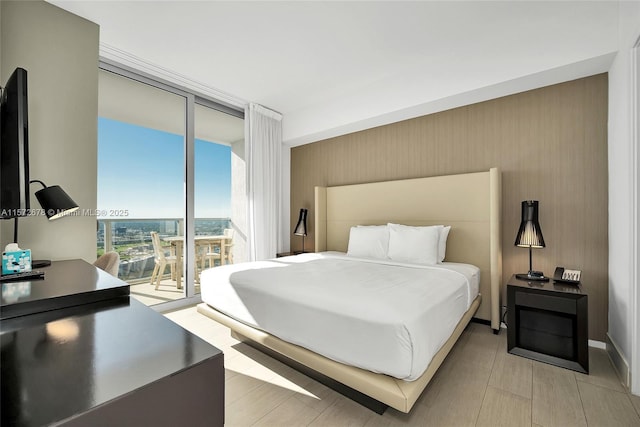 bedroom with access to exterior, a view of city, and floor to ceiling windows