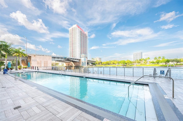 pool with a water view, a view of city, fence, and a patio