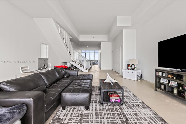 bedroom with a water view, a wall of windows, and concrete flooring