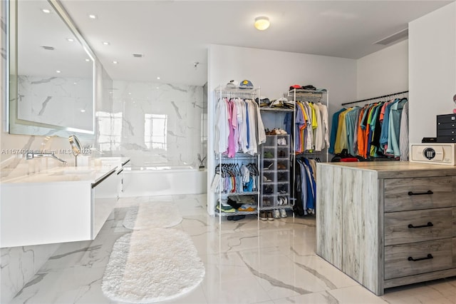 spacious closet with sink and light tile floors