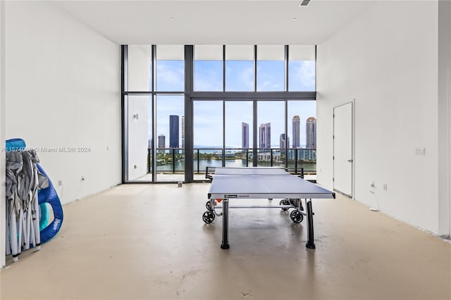 game room with floor to ceiling windows, plenty of natural light, and concrete flooring