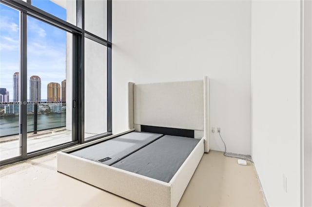 bedroom featuring expansive windows and a water view