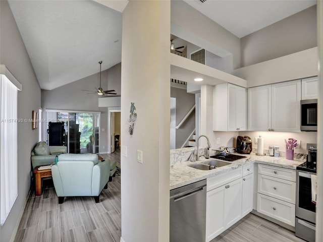 kitchen with high vaulted ceiling, ceiling fan, white cabinets, and appliances with stainless steel finishes