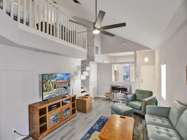 living room featuring high vaulted ceiling, ceiling fan, and light hardwood / wood-style flooring