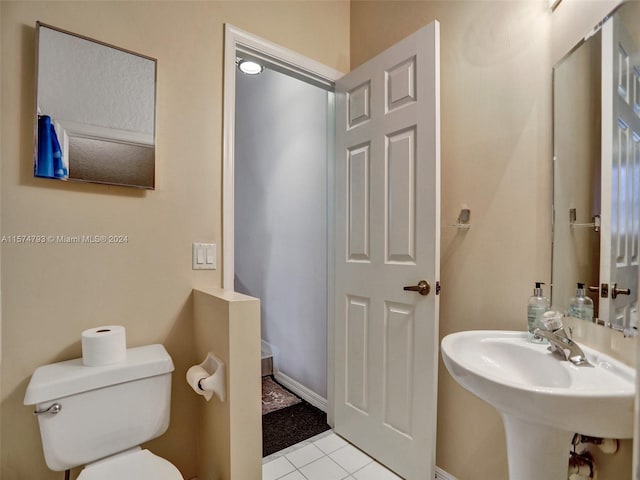 bathroom featuring tile flooring and toilet