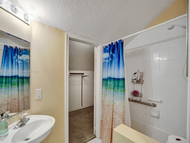 bathroom featuring sink, a textured ceiling, tile flooring, and shower / bath combo with shower curtain