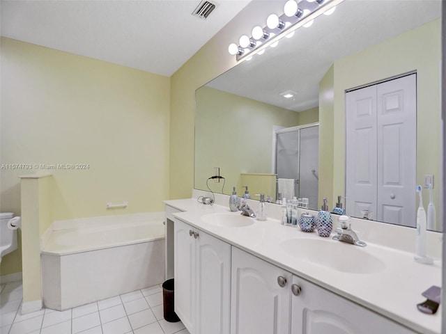 bathroom featuring dual vanity, tile flooring, a bathing tub, and toilet