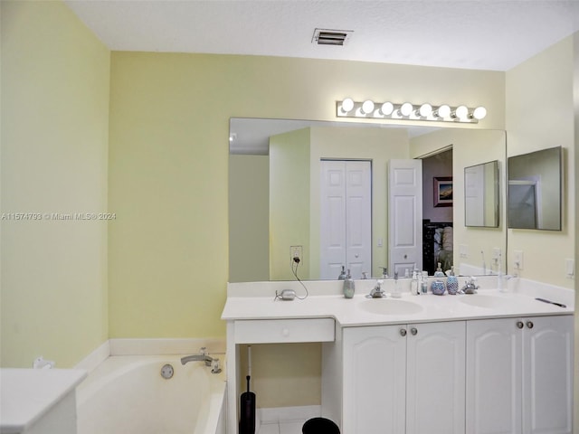 bathroom featuring a tub, tile floors, and double vanity