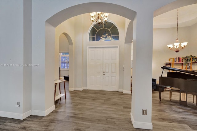 entryway featuring dark hardwood / wood-style floors, a chandelier, and a high ceiling