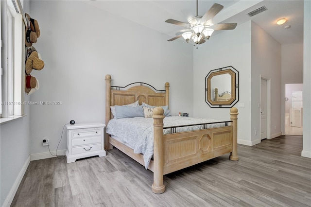 bedroom with light wood-type flooring, ensuite bath, and ceiling fan