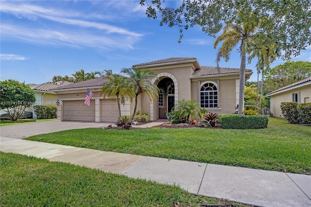 mediterranean / spanish-style home featuring a front yard and a garage