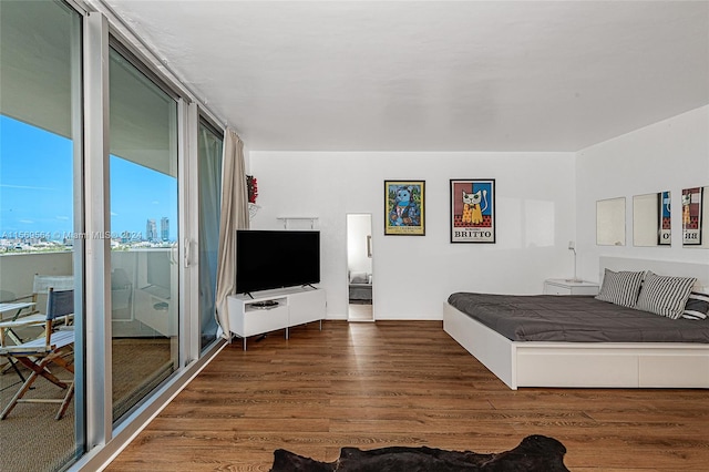 bedroom with dark hardwood / wood-style floors and a wall of windows