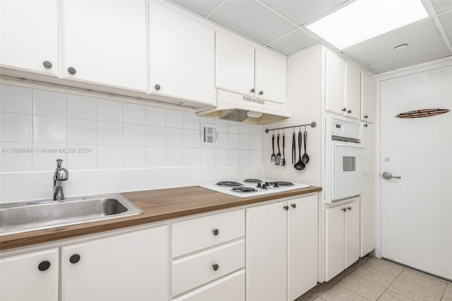 kitchen with custom exhaust hood, white cabinets, sink, white appliances, and tasteful backsplash