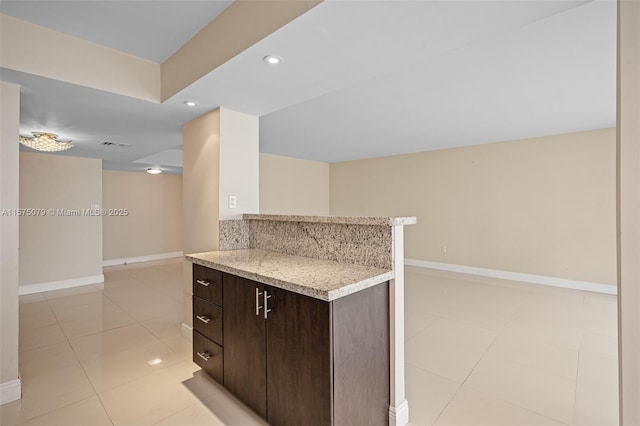 kitchen with dark brown cabinetry, tasteful backsplash, light tile patterned floors, baseboards, and recessed lighting