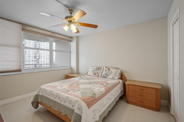 bedroom with ceiling fan, baseboards, and tile patterned floors