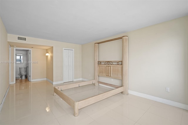 unfurnished bedroom featuring baseboards, a closet, visible vents, and tile patterned floors