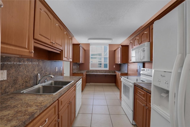 kitchen featuring white appliances, light tile floors, sink, tasteful backsplash, and a textured ceiling