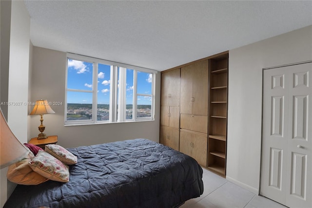 tiled bedroom featuring a textured ceiling