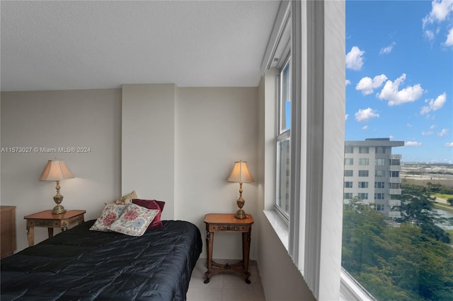 tiled bedroom featuring multiple windows and a textured ceiling