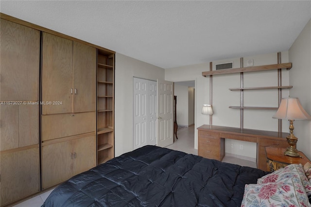 bedroom featuring a textured ceiling and light tile floors