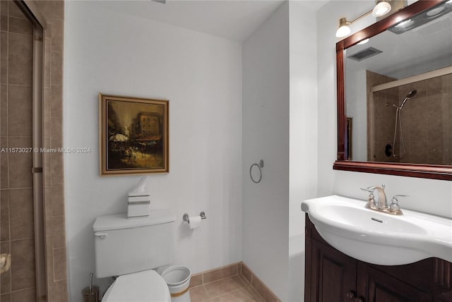 bathroom featuring tile flooring, vanity, and toilet