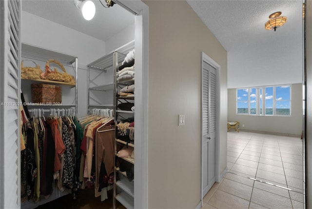 walk in closet with light tile floors