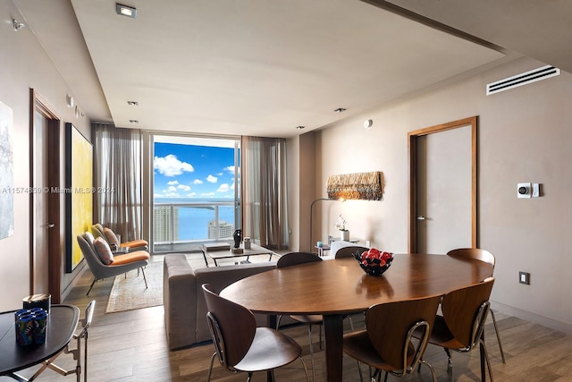 dining area with floor to ceiling windows and hardwood / wood-style floors