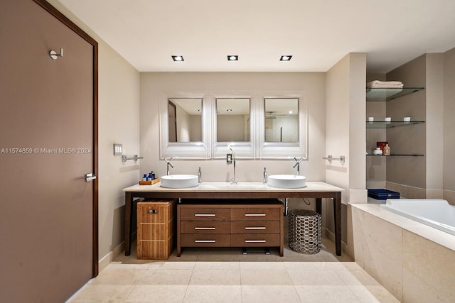 bathroom with tiled bath, vanity, and tile patterned floors