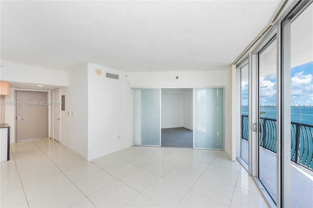 tiled empty room featuring a water view