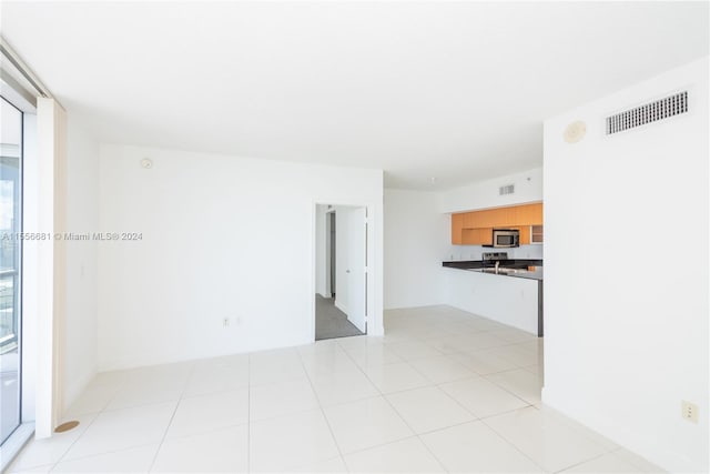 unfurnished living room featuring light tile flooring