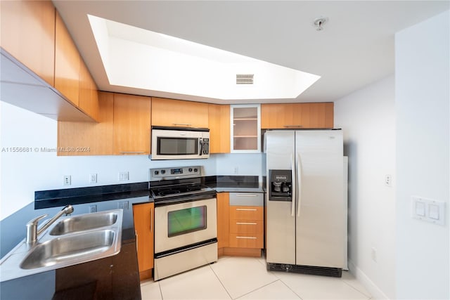 kitchen with sink, stainless steel appliances, and light tile floors