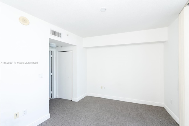 empty room featuring dark colored carpet