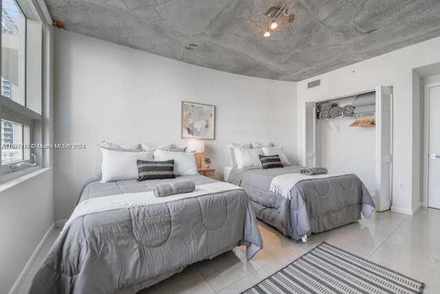 tiled bedroom with a closet