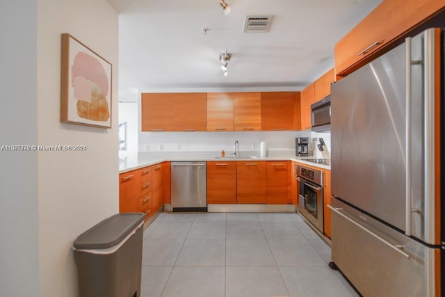 kitchen featuring light tile patterned floors, sink, and appliances with stainless steel finishes