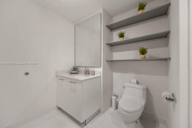 bathroom featuring tile patterned floors, vanity, and toilet