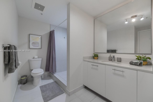 bathroom featuring tile patterned flooring, vanity, toilet, and walk in shower