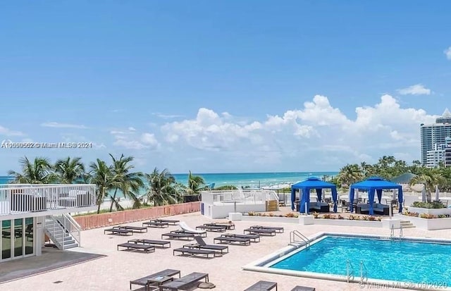 view of pool featuring a patio and a water view