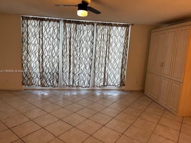 unfurnished room with ceiling fan and light tile floors