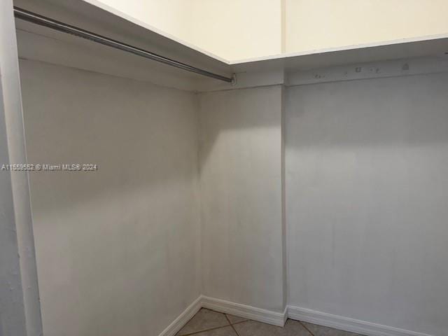 walk in closet featuring light tile floors